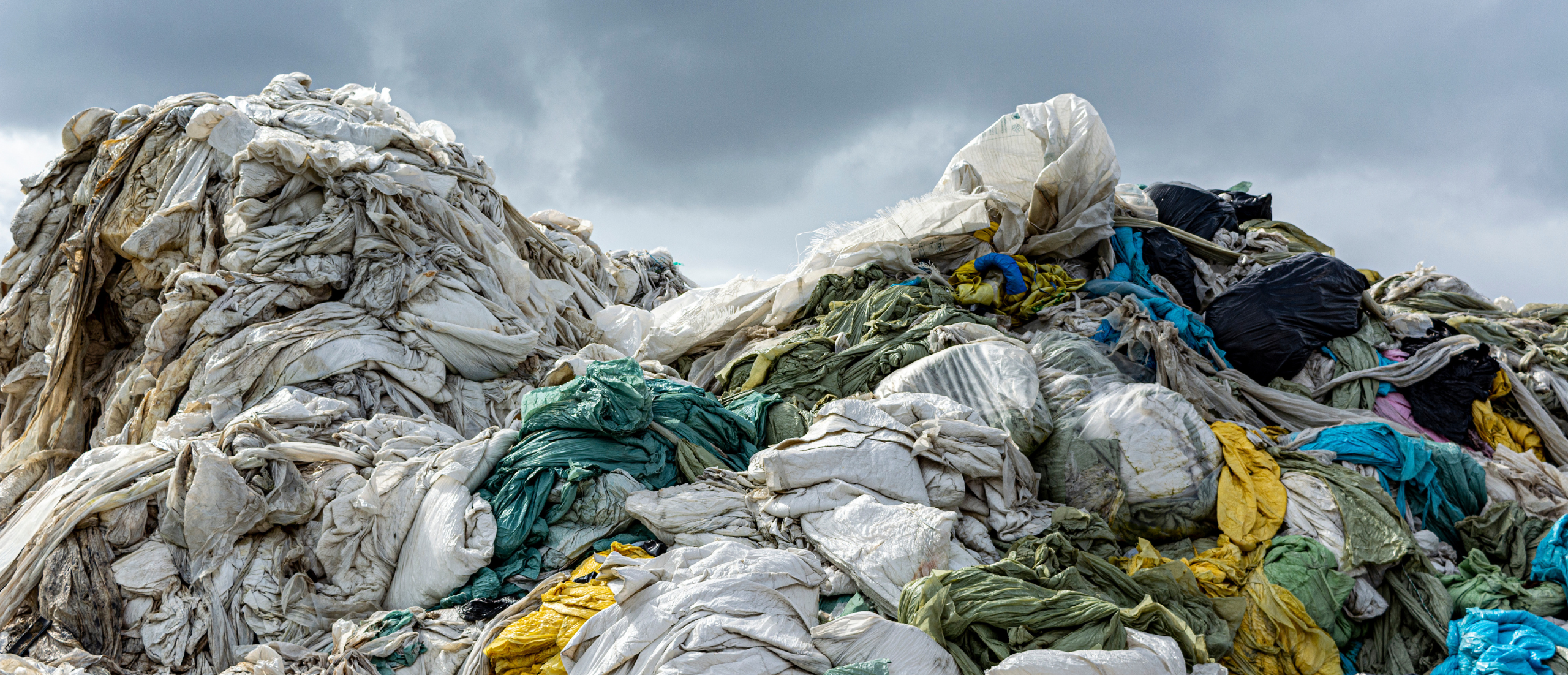 Photo of landfill pile full of textiles and clothing.